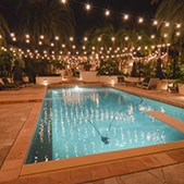 A pool area with overhead light strands